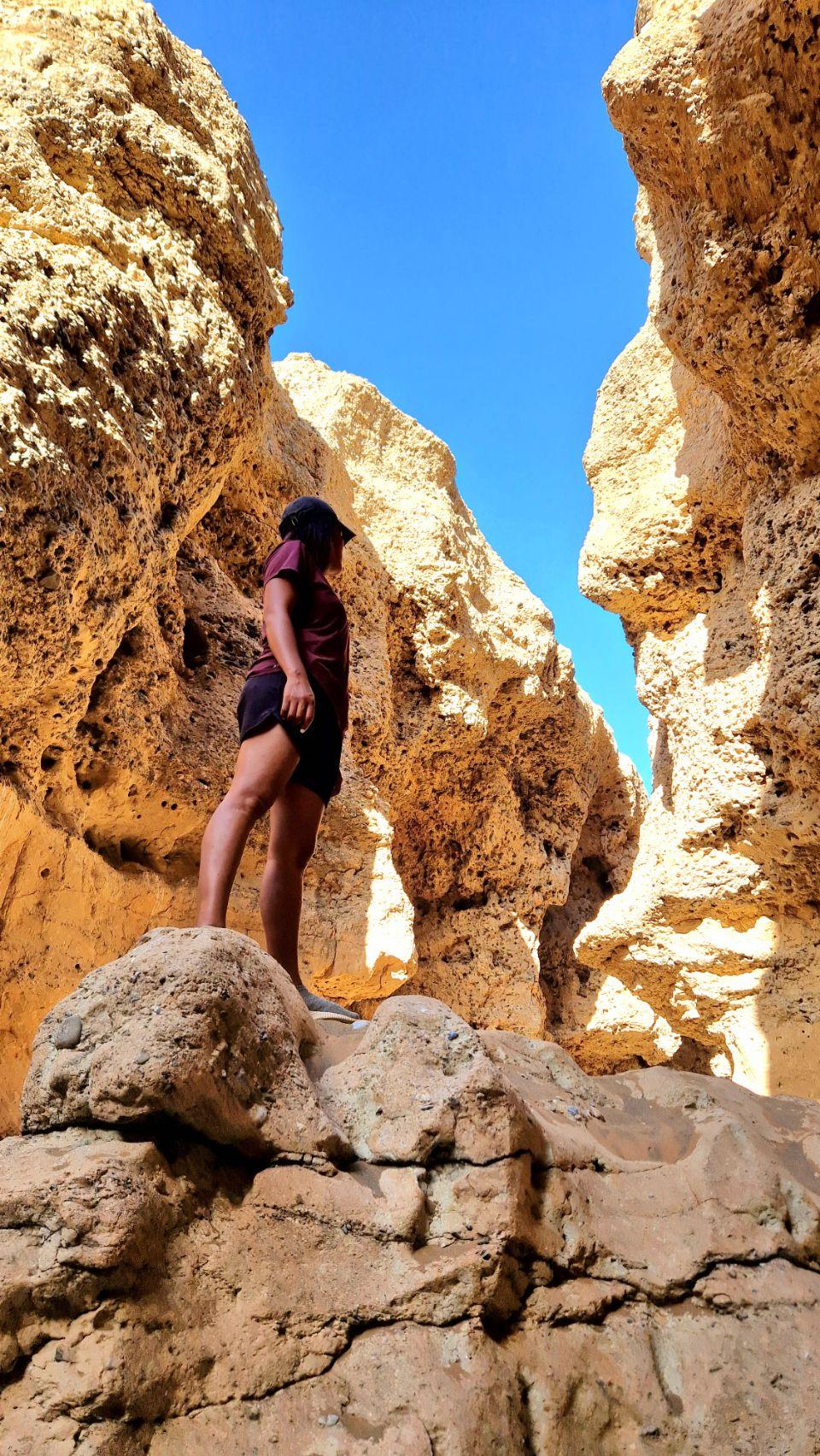 Max climbs through the narrow sandstone walls of Sesriem Canyon in the evening light.
