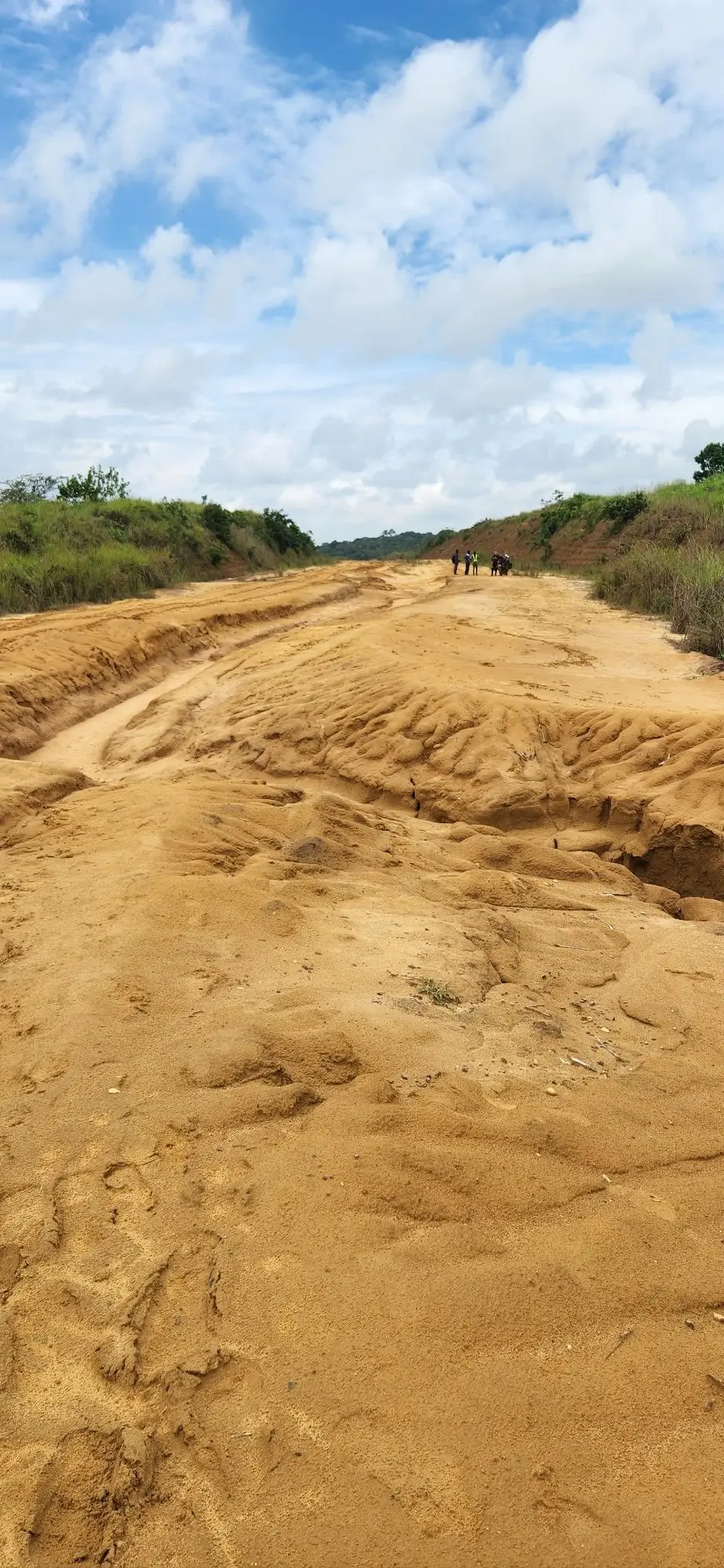 A sandy, lightly rutted red road cutting through the bush, calmer than what came after.